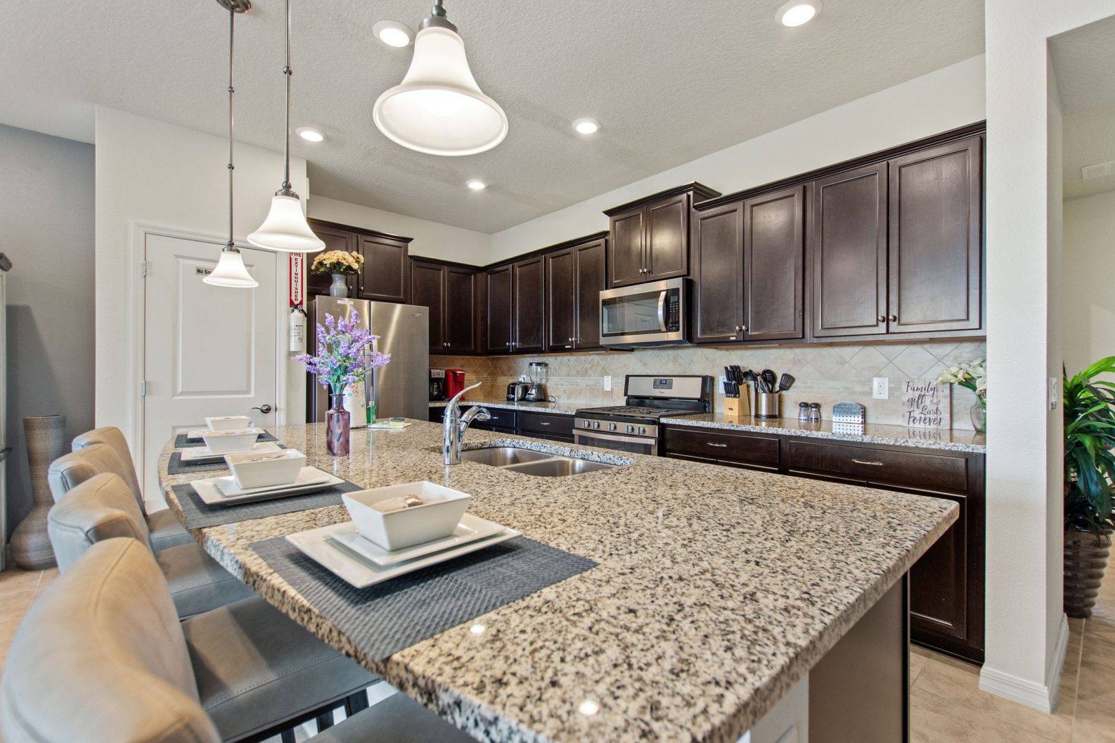 A kitchen with brown cabinets and granite counter tops.