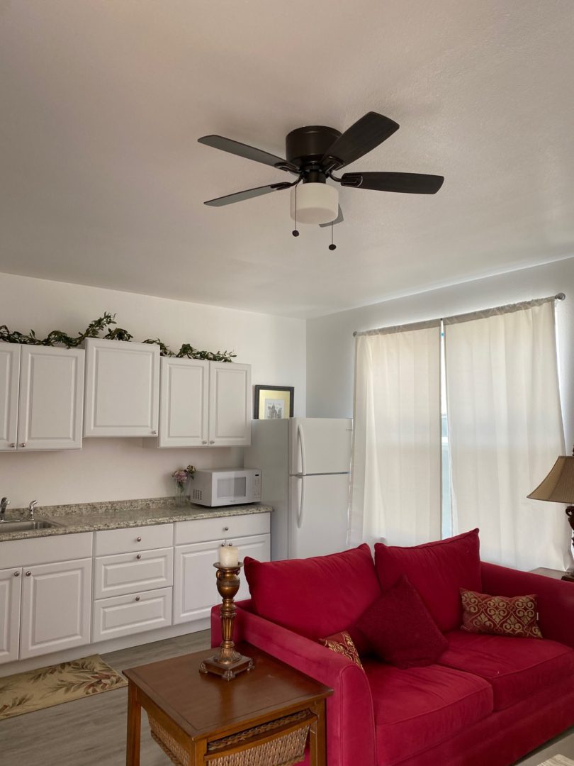 A living room with white cabinets and red couch.